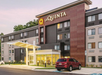Four-story La Quinta hotel with a welcoming entrance and a parked red SUV in front.