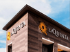 View looking up at the sign for the La Quinta Inn & Suites by Wyndham on the side of the hotel in Valdosta.