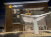 The covered front entrance to the La Quinta Inn & Suites by Wyndham Valdosta with outdoor lights on on a clear night.