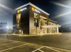 The front and side exterior of the La Quinta Inn & Suites by Wyndham Valdosta with a covered entrance on a clear night.