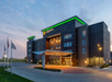 La Quinta hotel exterior at sunset with illuminated signage, modern architecture, and a welcoming entrance.