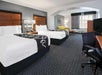 Two double beds, seating area, work desk and a flat-screen TV inside a non-smoking room.