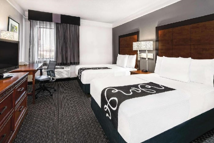 Two double beds, seating area, work desk and a flat-screen TV inside a non-smoking room.