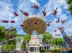 Park-goers are enjoying the carousel designed with vibrant colors as it spins around on a pleasant cloudy day at Idlewood.