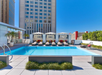 Outdoor pool with sun loungers and cabanas.