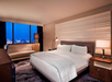 One king bed and an expanded windows with city view inside a guest room.