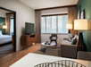 Seating area with sofa bed and flat-screen inside a guest room.