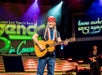 Willie Nelson performs with a guitar