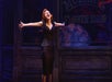 Audrey singing with her arms out in front of the flower shop in Little Shop of Horrors in New York City, New York.