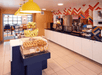A breakfast area with a countertop and an island full of food at the LivINN Hotel Minneapolis South / Burnsville.