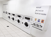 A wall of white washers and a laundry soap dispenser in the guest laundry area at the LivINN Hotel Minneapolis South / Burnsville.