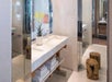 Guest bathroom with a single vanity mirror and fresh towels.
