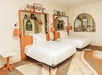 Two queen beds and bedside lamps in a guest room.