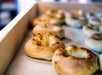 A tray of freshly baked bagels arranged on a parchment-lined baking sheet.