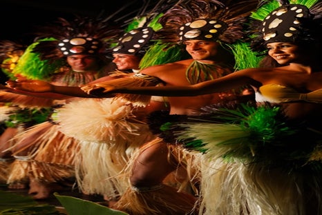 Hawaiian dancers in traditional hula costumes at the Lu`au Kalamaku in Lihue, HI.
