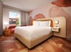 One king bed, seating area, and flat-screen TV inside a guest room.