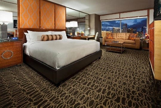 One king bed, seating area, and flat-screen TV inside a guest room.