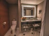 Fresh towels, bathroom amenities, and back-lighted mirror inside a private bathroom.