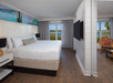 A king suite with a separate living area with sofa bed, private balcony and resort/garden view at Margaritaville Beach House Key West, FL.