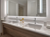 A guest room bathroom with dual marble vanities and lighted mirror at Margaritaville Beach House Key West, FL.