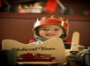 A child is dressed up with a crown, sword, and shield