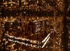 A golden, intricately detailed antique machine sits in a reflective room filled with warm lights, creating a luxurious and ornate atmosphere.