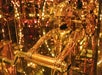 A golden humanoid robot holding a handlebar, surrounded by mirrors and warm, ambient lighting.