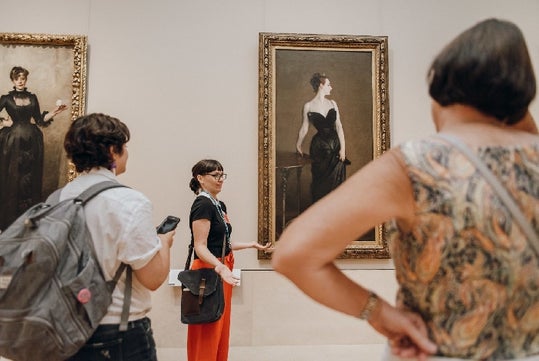 People inside the Met examining this artwork of a woman on the Met Express: Highlights of the Metropolitan Museum of Art in New York City, New York, USA.