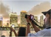 People taking photos of a city skyline at dusk.