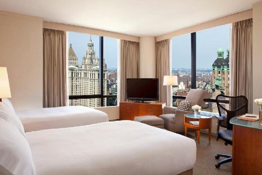 2 Double beds, city view, flat-screen TV, work desk, chair at Millennium Hotel, NY.
