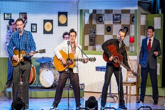 Three men in different 50s themed costumes standing at microphones playing guitars at the Million Dollar Quartet in Branson, Missouri.