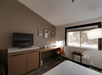 Flat screen TV, desk, and chair in a guest room.