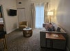 Living room with a sofa bed, flat-screen TV, end table and an armchair.