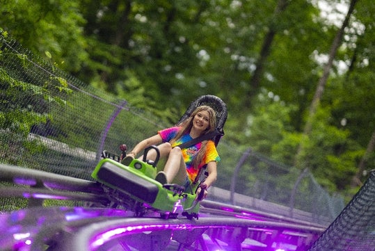 A girl in tie-dye rides the Moonshine Mountain Coaster in Gatlinburg, TN
