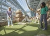 A group of two women and a boy playing mini-golf at Moose Mountain Adventure Golf at the Mall of America.