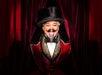 Person in a theatrical costume with a top hat and mustache, standing in front of red curtains, smiling broadly.