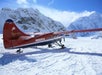The plane landing on the glacier with the mountains in the background in Talkeetna, Alaska.