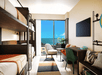 2 Bunk beds, flat-screen TV, floor-to-ceiling windows and a work desk inside a guest room at Moxy Miami South Beach, FL.