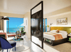 1 King bed, flat-screen TV, floor-to-ceiling window and a seating area inside a guest room at Moxy Miami South Beach, FL.