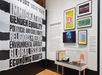 Exhibit wall with bold text on activism topics, framed posters, an introduction panel, and a display case with protest objects and memorabilia.