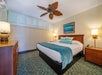 One king bed, bedside lamps, and a dresser inside a guest room.