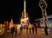 A group of people stand in front of a large illuminated Hard Rock Cafe guitar sign at night in an outdoor neon sign exhibit.