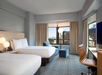 2 Double beds, sofa chair, work desk, flat-screen TV at New York Hilton Midtown, NY.