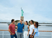 Five people smiling on a boat with the Statue of Liberty in the background.