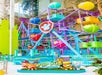 Colorful indoor amusement ride with a Paw Patrol theme, featuring cartoon character figures and a Ferris wheel with multicolored cabins.