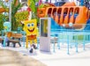 SpongeBob and Squidward figures at an amusement park near an orange ride named "Crosstown Express," with vibrant colors and tropical decor.