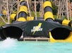 Entrance of a water slide ride named "Black Thunder," featuring black and yellow tubed slides and a splash pool at the bottom.