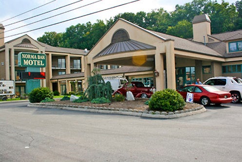 Exterior view of a two-story motel with cars parked in front. The sign reads "Norma Dan Motel.