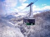 The Ober Mountain Tram gliding over a snow-covered Smoky Mountain landscape, offering stunning views of the valley and frosted trees below.