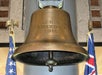 The historical USS Arizona's Bell, a large antique bronze bell with "U.S.S. ARIZONA 1916" engraved on the front and flags on both sides.